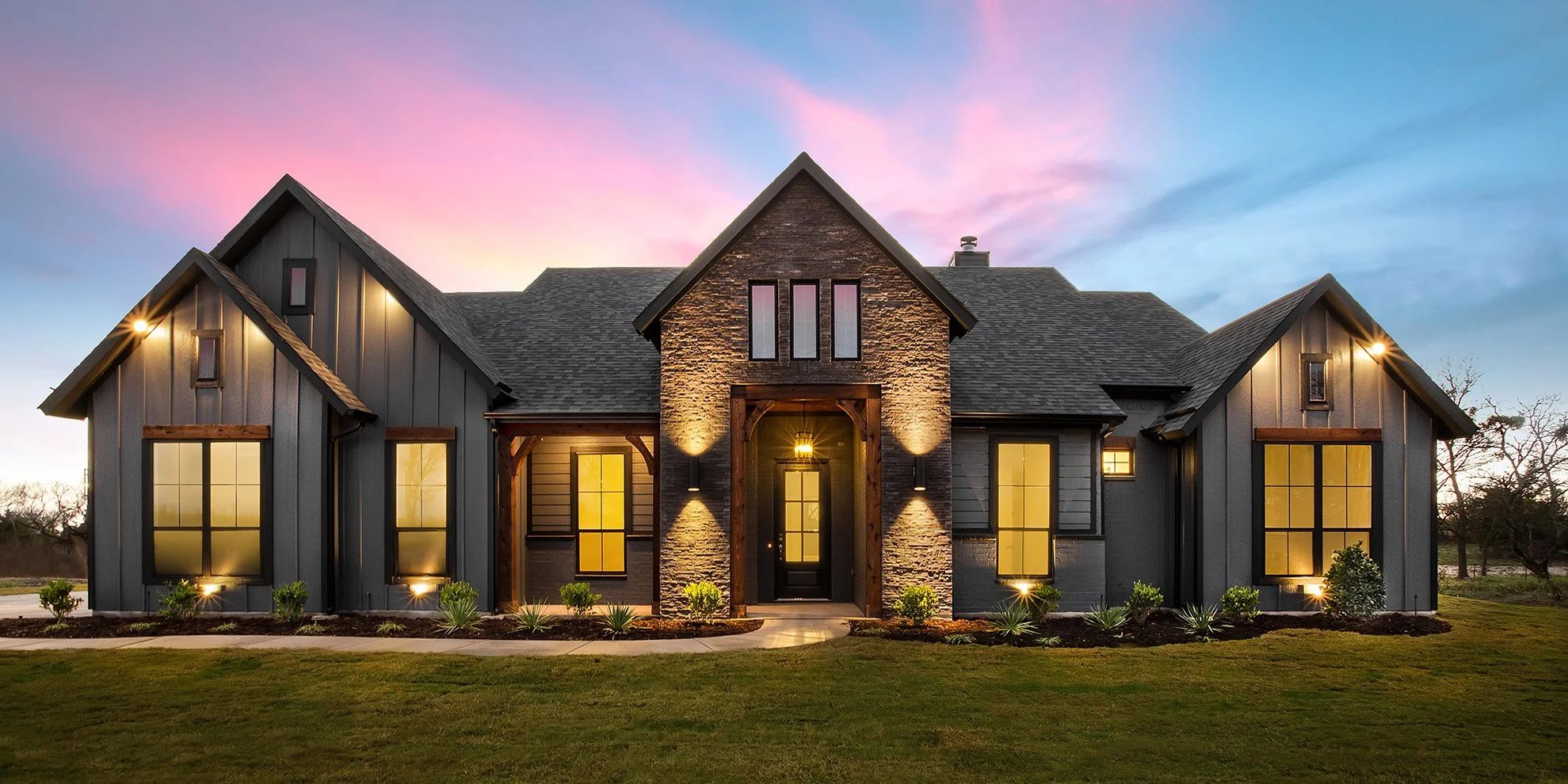 Modern farmhouse style home exterior lit up at twilight